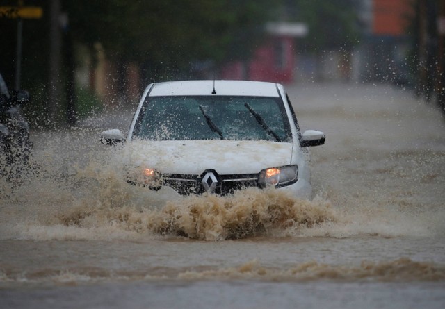 Sebuah mobil melewati jalan yang banjir saat hujan lebat, di Juarez, Meksiko, Senin (5/9/2022). Foto: Daniel Becerril/Reuters