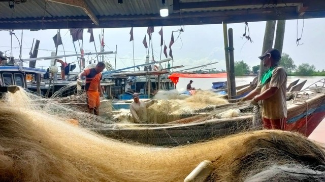 Para nelayan di Nipah Panjang memakirkan perahu pompong dan mengeluarkan jaring untuk menangkap ikan. (Foto: Jambikita)