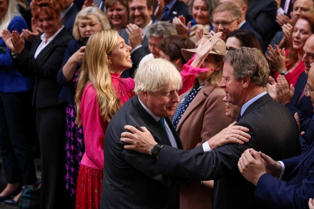 Perdana Menteri Inggris Boris Johnson, bersama istrinya Carrie Johnson, menyapa orang-orang setelah menyampaikan pidato pada hari terakhirnya di kantor, di luar Downing Street, di London, Inggris, Selasa (6/9/2022). Foto: Henry Nicholls/REUTERS