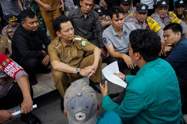 Pj Gubernur Aceh Achmad Marzuki duduk di lantai mendengar orasi dari beberapa mahasiswa dalam aksi demo tolak kenaikan harga BBM di halaman kantor gubernur, Selasa (6/9). Foto: acehkini