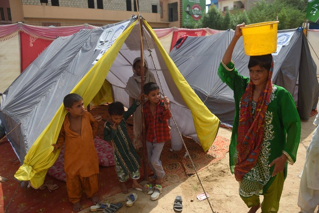 Anak-anak pengungsi yang terkena dampak banjir di dalam tenda kamp darurat yang didirikan oleh Yayasan Alkhidmat Pakistan di Karachi, Selasa (6/9/2022). Foto: Rizwan Tabassum/AFP