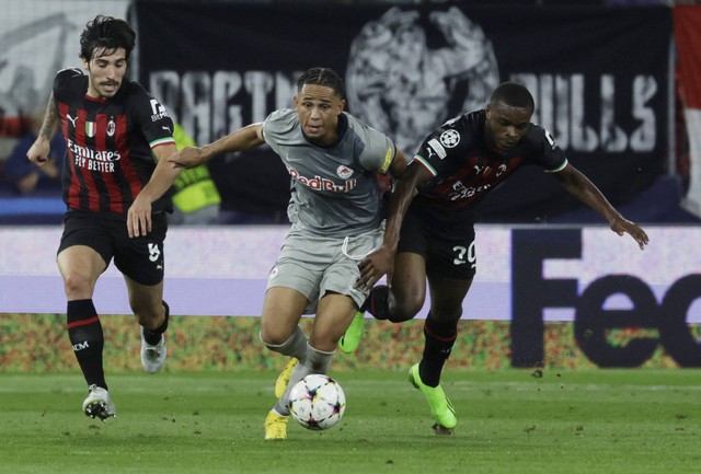 Noah Okafor dari FC Salzburg duel dengan Pierre Kalulu dan Sandro Tonali dari AC Milan saat pertandingan di Red Bull Arena Salzburg, Salzburg, Austria pada Selasa (6/9/2022). Foto: Leonhard Foeger/Reuters
