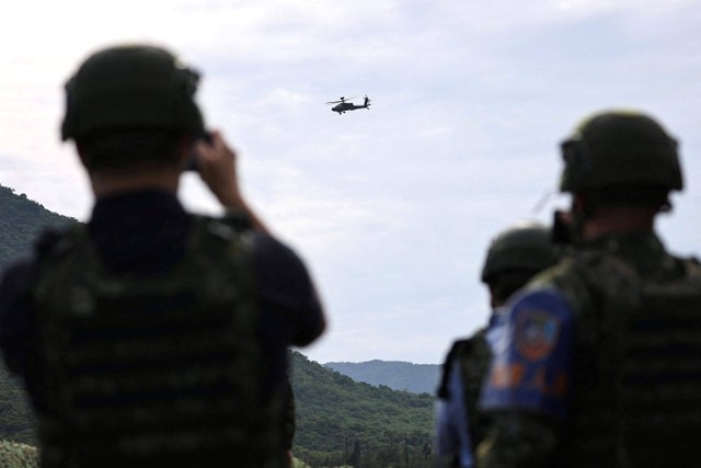 Anggota media mengambil foto Apache AH-64 selama latihan militer di Pingtung, Taiwan. Foto: Ann Wang/REUTERS