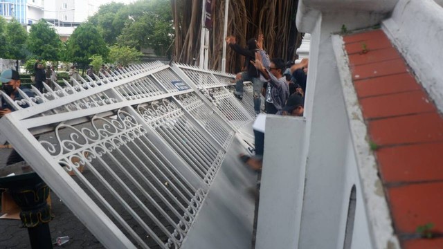 Massa aksi dalam unjuk rasa menolak kenaikan harga BBM robohkan pagar DPRD DIY, Rabu (7/9/2022). Foto: Arfiansyah Panji Purnandaru/kumparan