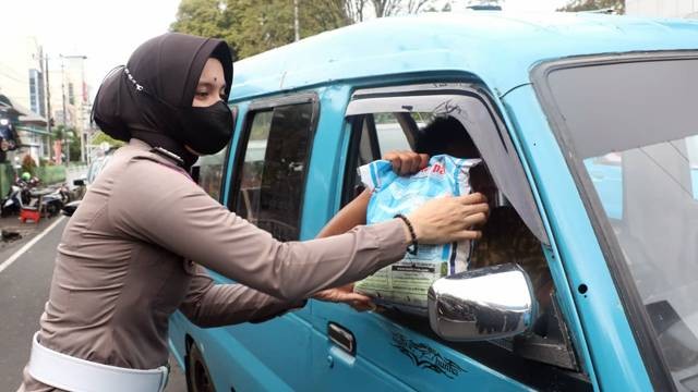 Polwan Polda Sulawesi Utara saat membagikan beras 5 kilogram untuk sopir mikrolet. Bantuan ini diberikan kepada warga terdampak penyesuaian harga BBM Subsidi.