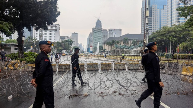 Polisi mulai menutup Jalan Medan Merdeka Barat dekat Patung Kuda, Jakarta Pusat, jelang aksi unjuk rasa menolak kenaikan harga BBM, Kamis (8/9).
 Foto: Jonathan Devin/kumparan