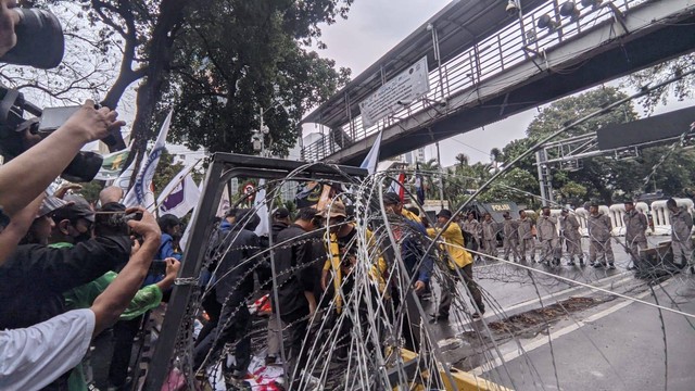 Massa aksi tolak kenaikan harga BBM terobos kawat berduri di Patung Kuda, Jakarta Pusat, Kamis (8/9/2022). Foto: Jonathan Devin/kumparan
