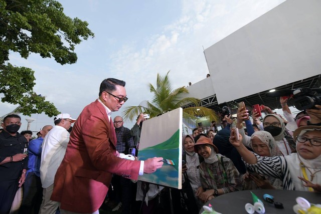 Pengunjung Makassar International Eight and Forum Festival (MIEFF) 2022 di kawasan Pantai Losari Makassar, berdesakan menyaksikan langsung aksi Ridwan Kamil melukis. Foto: Humas Jabar