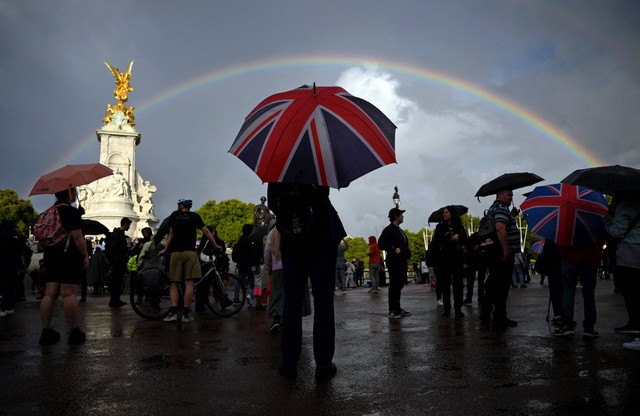 Pelngi muncul di antara kerumunan warga di dekat Queen Victoria Memorial di seberang Istana Buckingham, London pusat, Kamis (8/9/2022). Foto: Daniel Leal/AFP