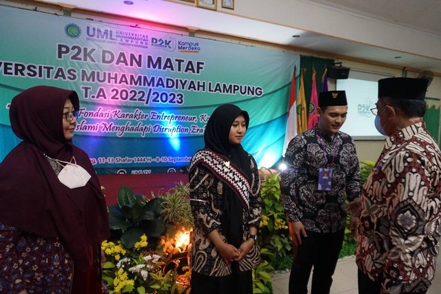 Ketua PWM Lampung Prof. Dr. Marzuki Noor, M.S menyematkan tanda peserta P2K dan MATAF Tahun 2022 dan didampingi Wakil Rektor 1 UML Dr. Any Nurhayaty, M.Si. Psikolog. (Foto Dokumentasi Humas UML)