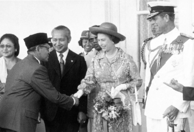 Ratu Inggris Elizabeth II, diapit oleh Presiden Indonesia Suharto, kiri, dan Pangeran Philip, diperkenalkan kepada anggota Kabinet Indonesia, di Jakarta, pada 18 Maret 1974. Foto: AP Photo