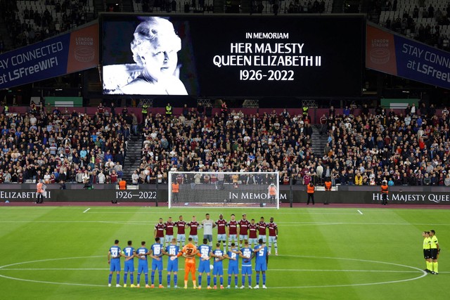 Para pemain mengheningkan cipta beberapa menit sebelum pertandingan untuk mengenang kematian Ratu Inggris Elizabeth di Stadion London, London, Inggris, Kamis (8/9/2022). Foto: Peter Cziborra/Reuters