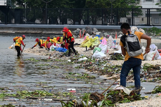 Relawan mengumpulkan sampah dari pantai di Teluk Manila, Jumat (9/8/2022). Foto: Jam Sta Rosa/AFP