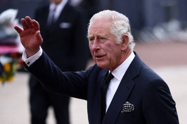 Raja Inggris Charles melambai saat dia berjalan di luar Istana Buckingham, di London, Inggris, Jumat (9/9/2022). Foto: Henry Romero/REUTERS