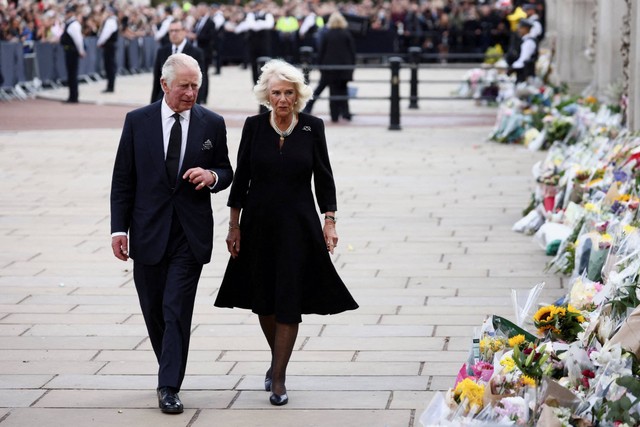 Raja Inggris Charles berjalan bersama Ratu Camilla di sepanjang pagar Istana Buckingham, di London, Inggris, Jumat (9/9/2022). Foto: Henry Romero/REUTERS