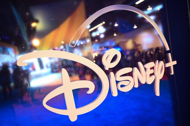 Pengunjung tercermin pada logo Disney+ dalam Walt Disney D23 Expo di Anaheim, California  Jumat (9/9/2022). Foto: Patrick T. Fallon/AFP
