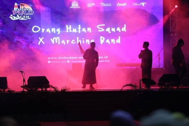 Grup musik Oranghutan Squad saat tampil berkolaborasi dengan Marching Band memeriahkan acara puncak Festival Pulo Aceh 2022 di Taman Sultanah Safiatuddin, Banda Aceh. Foto: Abdul Hadi/acehkini