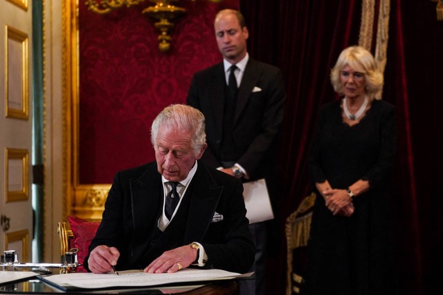Raja Inggris Charles III menandatangani sumpah untuk menegakkan keamanan Gereja di Skotlandia saat peresmiannya sebagai raja baru Inggris di Istana St James, London, Inggris, Sabtu (10/9/2022). Foto: Victoria Jones/AFP