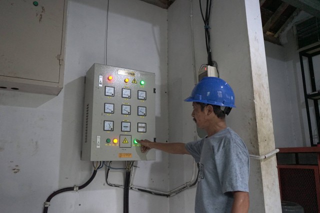 Teknisi PLTMH Kedungrong, Widarto sedang mengecek kotak transimisi. Foto: Arif UT