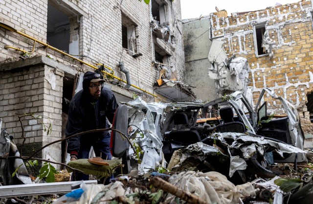 Sejumlah warga menyelamatkan barang-barang mereka dari sebuah bangunan tempat tinggal di Mykolaiv, Ukraina, Minggu (11/9/2022). Foto: Umit Bektas/Reuters