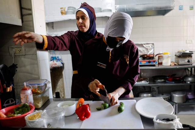Koki Palestina Amena Al-Hayek mengamati staf yang bekerja di restoran khusus wanita yang baru dibuka, bernama Sabaia VIP, di Kota Gaza. Foto: Mohammed Salem/REUTERS