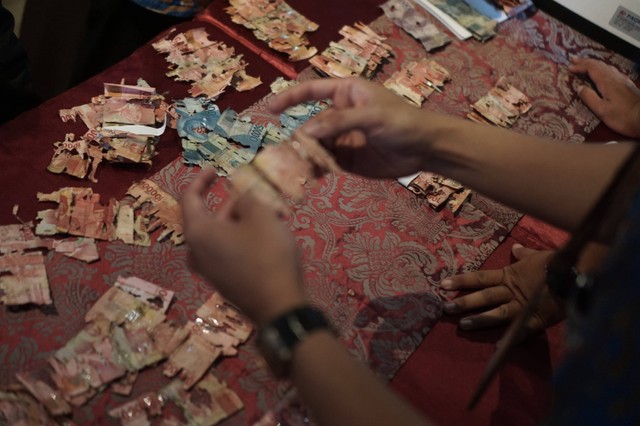 Petugas Bank Indonesia Solo memeriksa uang rusak milik Samin akibat dimakan rayap di Kantor Bank Indonesia, Solo, Jawa Tengah, Selasa (13/9/2022). Foto: Mohammad Ayudha/Antara Foto