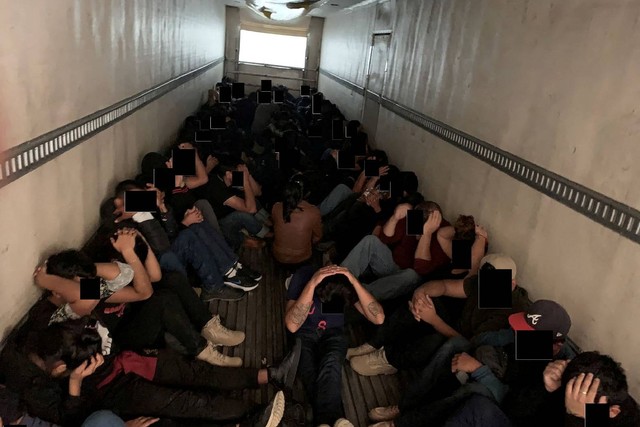 Para migran duduk dalam truk, yang diyakini telah melintasi perbatasan dari Meksiko ke Amerika Serikat, saat dicegat oleh petugas penegak hukum di Texas, AS, Selasa (13/9/2022). Foto: Departemen Kehakiman AS/Handout via REUTERS