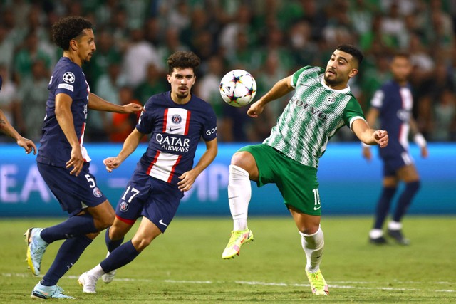 Pemain Paris Saint-Germain (PSG) Marquinhos dan Vitinha berebut bola dengan pemain Maccabi Haifa pada pertandingan Grup H Liga Champions di Stadion Sammy Ofer, Haifa, Israel. Foto: Ronen Zvulun/REUTERS