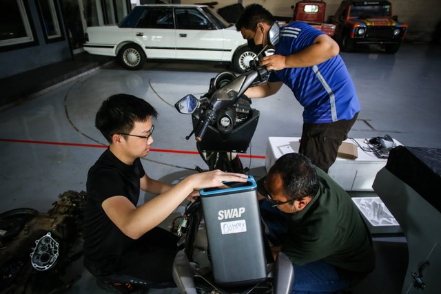 Pekerja memasang baterai saat mengonversi sepeda motor konvensional menjadi sepeda motor listrik di Lengkong, Tangerang Selatan, Banten, Kamis (15/9/2022). Foto: Rivan Awal Lingga/ANTARA FOTO