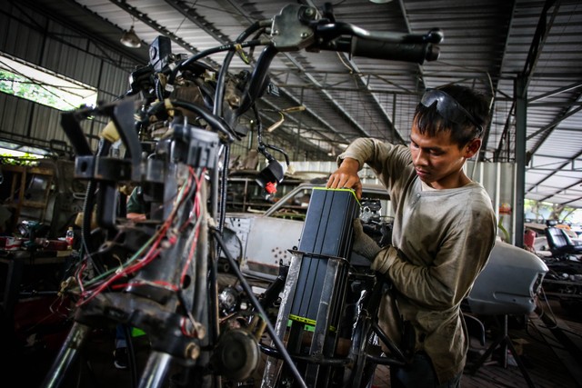 Pekerja memasukkan baterai saat mengonversi sepeda motor konvensional menjadi sepeda motor listrik di Lengkong, Tangerang Selatan, Banten, Kamis (15/9/2022). Foto: Rivan Awal Lingga/ANTARA FOTO