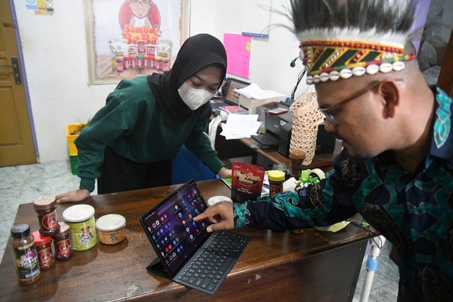 Pelaku UMKM Muhammad Yamin Rachman bersama pekerja memeriksa pesanan produk Sambal Baba melalui media sosial di Jayapura, Papua. Foto: ANTARA FOTO/Arif Firmansyah