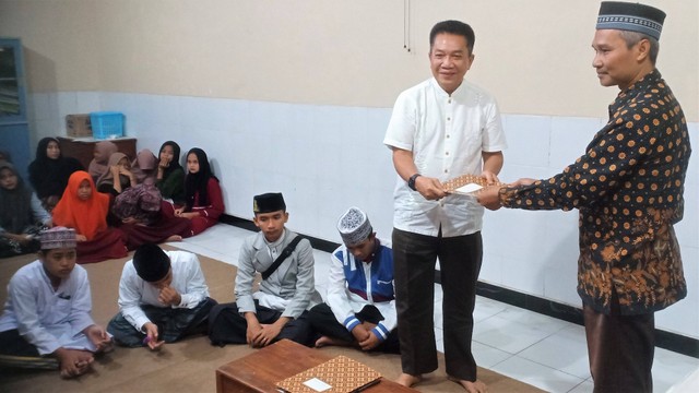 Vice Program Director Bakti Sosial Djarum Foundation, Achmad Budiharto, menyerahkan dokumen kerja sama kepada Ketua Yayasan Pondok Pesantren Yatim Hajjah Patisa, Hasyim, Jumat (16/09/2022) malam. FOTO: Agung Santoso