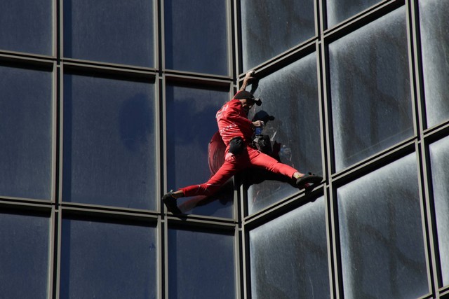 "Spiderman" Prancis, Alain Robert, memanjat gedung pencakar langit TotalEnergies di La Defense dekat Paris, Prancis, Sabtu (17/9/2022). Foto: Lucien Libert/REUTERS