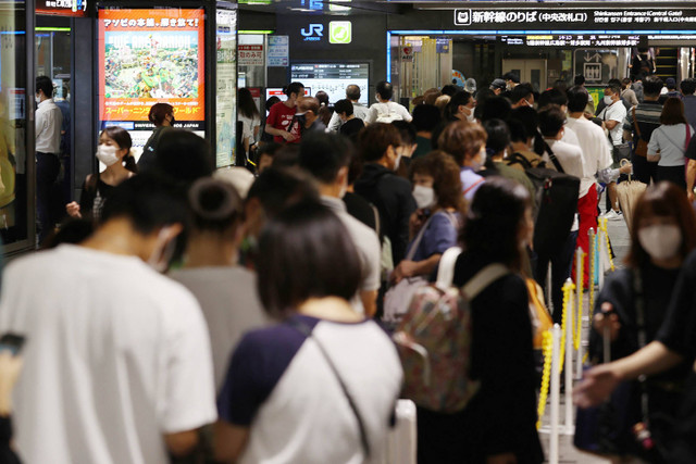 Penumpang berkumpul saat layanan kereta ditangguhkan karena Topan Nanmadol mendekati wilayah Kyushu, di stasiun Hakata Fukuoka, Jepang, Minggu (18/9/2022). Foto: JIJI PRESS / AFP