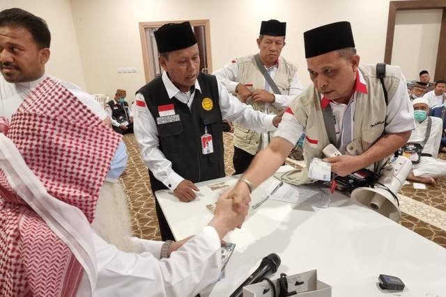 Syaikh Abdul Latief Baltou membagikan uang bagi jemaah haji Aceh. Foto: Muhammad Iqbal/kumparan