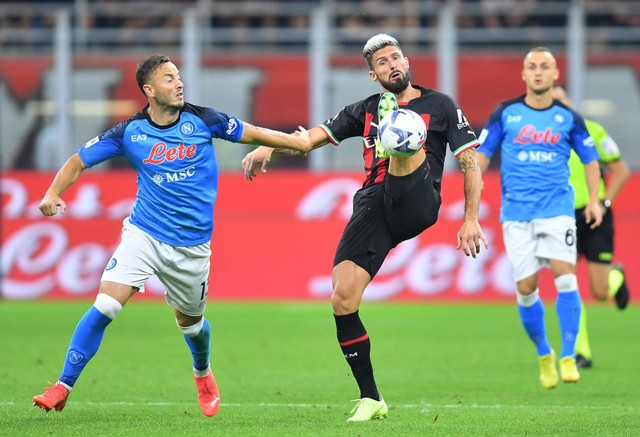 Pemain Napoli Amir Rrahmani duel dengan Olivier Giroud dari AC Milan di San Siro, Milan, Italia. Foto: Daniele Mascolo/Reuters