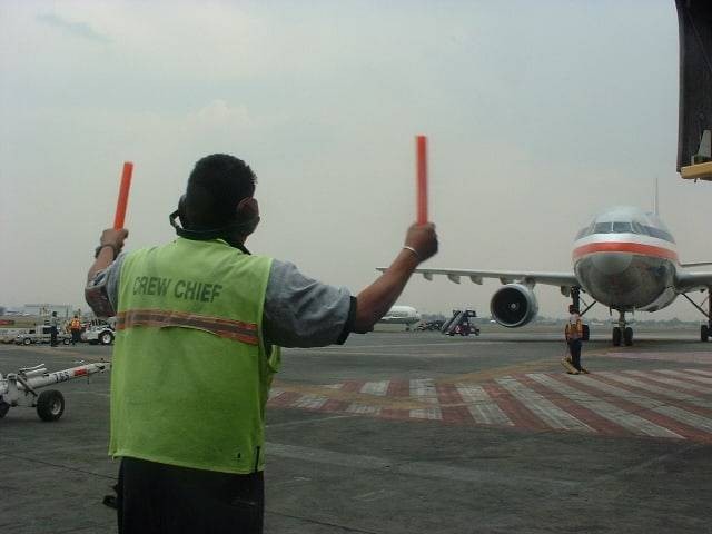 Ilustrasi profesi tukang parkir pesawat atau marshaller. Foto: Dok. Wikimedia Commons