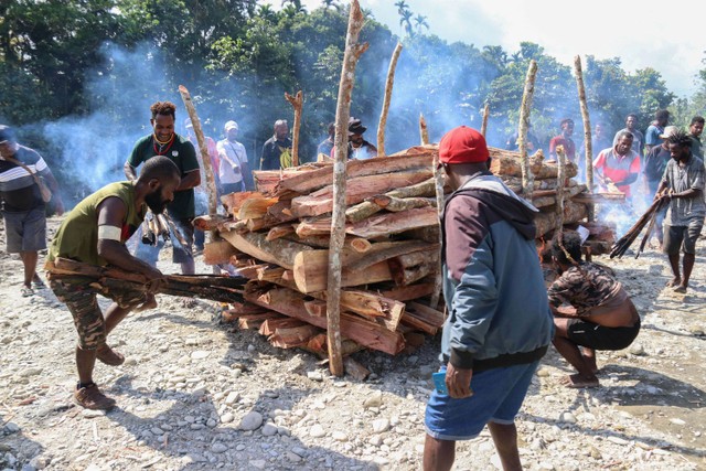 Keluarga mengelilingi jenazah korban pembunuhan dan mutilasi saat kremasi di Mimika, Papua, Jumat (16/9/2022). Foto: Saldi Hermanto/ANTARA FOTO