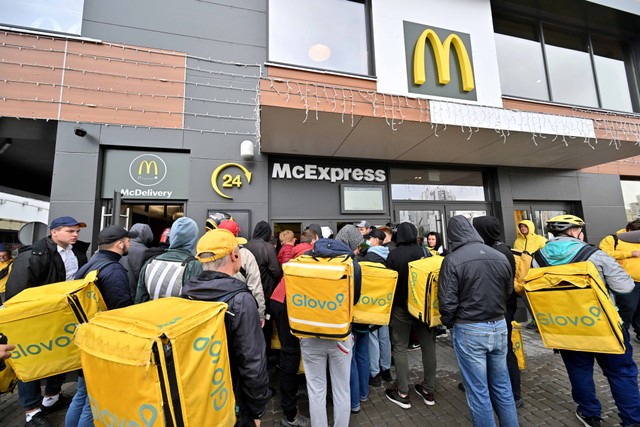 Sejumlah kurir menunggu pesanan di resto siap saji McDonald di Kyev, Ukraina pada 20 September 2022. Foto: Sergei Supinsky/AFP