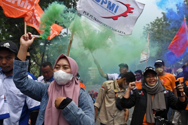 Buruh membawa kembang api asap saat berunjuk rasa di depan Balai Kota DKI Jakarta, Jakarta, Rabu (21/9). Foto: Aditya Pradana Putra/ANTARA FOTO