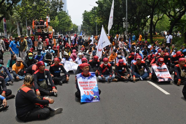 Sejumlah buruh duduk menutup Jalan Medan Merdeka Selatan saat berunjuk rasa di depan Balai Kota DKI Jakarta, Jakarta, Rabu (21/9).  Foto: Aditya Pradana Putra/ANTARA FOTO