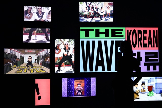 Seorang asisten galeri melihat instalasi K-pop selama tampilan pers pameran "Hallyu! The Korean Wave" di V&A, London, Inggris, Selasa (21/9/2022). Foto: Tom Nicholson/Reuters