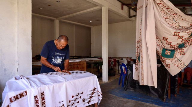 Oliya sedang membersihkan tetesan lilin yang keluar dari pola saat dilukis pada sehelai kain di Rumoh Batik Aceh, kawasan Pagar Air, Kecamatan Ingin Jaya, Aceh Besar, Kamis (22/9). Foto: Suparta/acehkini