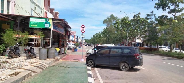 Bahu jalan yang baru dilebarkan Pemko Batam di kawasan greenland ramai kendaraan parkir melintang. Kendati sejumlah rambu larangan parkir ditempatkan di lokasi itu. (Foto: Batamnews)