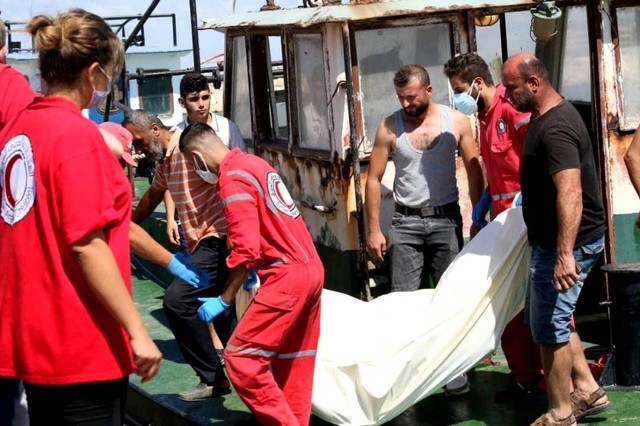 Petugas Bulan Sabit Merah Suriah selama proses evakuasi para migran dari kapal yang tenggelam di Tartous, Suriah, Jumat (23/9/2022). Foto: Syrian Red Crescent/via REUTERS