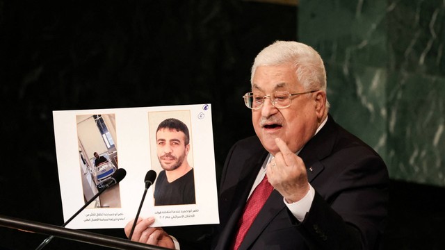 Presiden Palestina Mahmoud Abbas mengangkat foto selama pidatonya di Majelis Umum PBB ke-77 di markas besar PBB di New York City, New York, AS, Jumat (23/9/2022). Foto: Caitlin Ochs/REUTERS