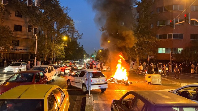 Sebuah sepeda motor polisi terbakar saat protes kematian Mahsa Amini, di Teheran, Iran, Senin (19/9/2022). Foto: WANA via REUTERS