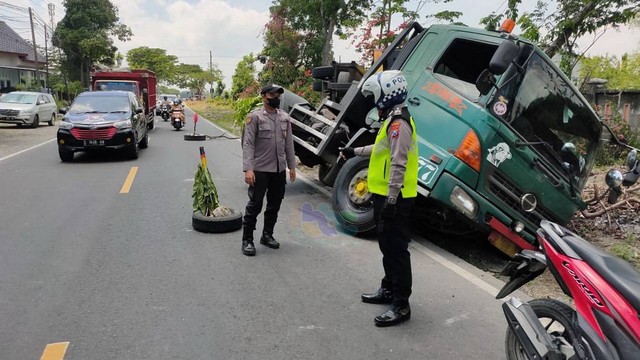 Petugas saat lakukan pengaturan jalur di lokasi terjadinya kecelakaan lalu-lintas tunggal di jalan raya Desa Prayungan, Kecamatan Sumberrejo, Kabupaten Bojonegoro. Sabtu (24/09/2022) (foto: Dok Istimewa)