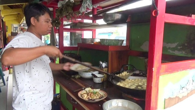 Juru masak sedang meracik tahu kupat yang akan disajikan kepada pelanggan. FOTO: Agung Santoso.