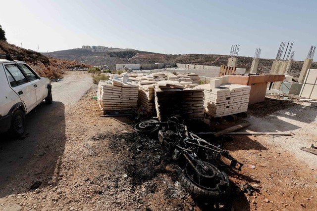 Sebuah kendaraan yang terbakar tergeletak di tanah di lokasi baku tembak antara gerilyawan Palestina dan pasukan Israel dalam serangan di Nablus, Tepi Barat yang diduduki Israel, Minggu (25/9). Foto: Raneen Sawafta/ REUTERS